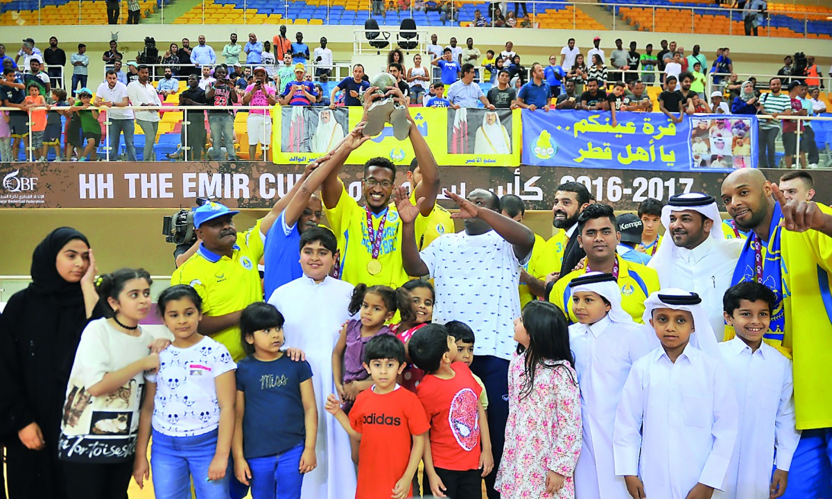 Al Gharafa players celebrate their Emir Cup victory with young fans at the Al Gharafa Indoor Hall on Friday. 