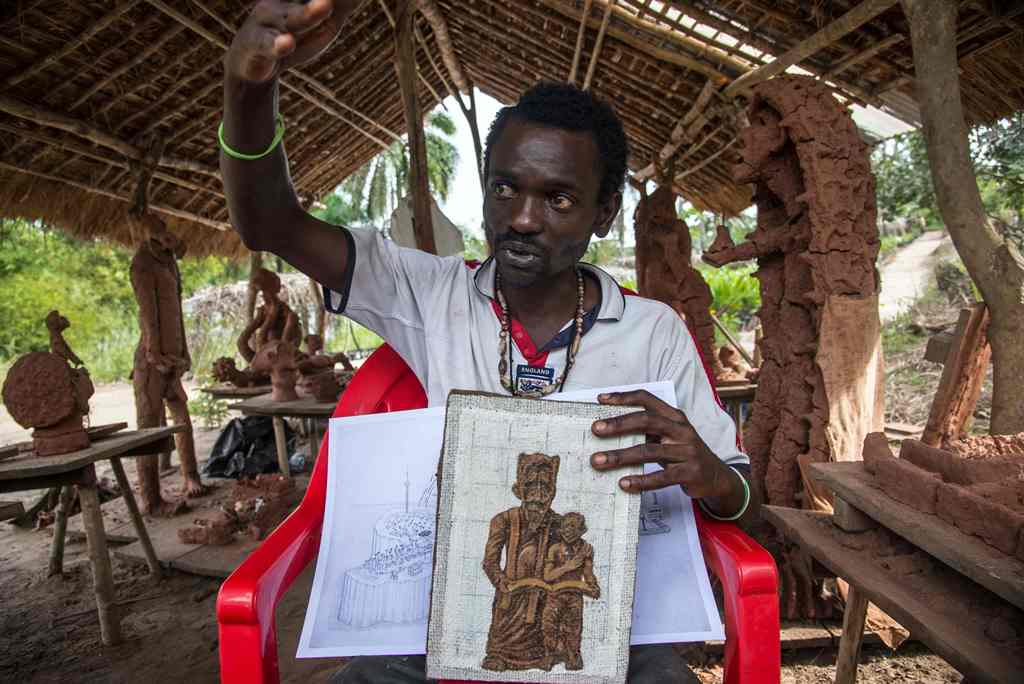 Congolese artist Cedrick Tamasala, vice president of the (CAPTC) Congolese Plantation Workers Art League, displays his first artwork made during a workshop in 2015 at the Kibangu Camp in Lusanga on April 21, 2017. AFP / Junior D. KANNAH
