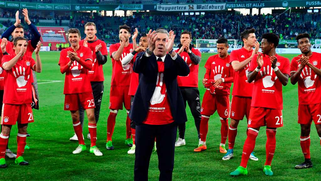 Bayern Munich's Italian head coach Carlo Ancelotti (C) and his players celebrate after winning the German Bundesliga title and the German first division Bundesliga football match between VfL Wolfsburg and Bayern Munich on April 29, 2017 in Wolfsburg, nort