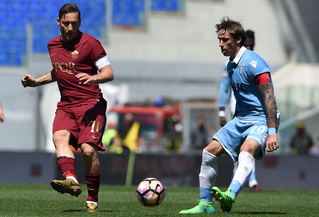 Roma's forward from Italy Francesco Totti (L) vies with Lazio's midfielder from Argentina Lucas Biglia during the Italian Serie A football match Roma vs Lazio at the Olympic Stadium in Rome on April 30, 2017. / AFP / FILIPPO MONTEFORTE