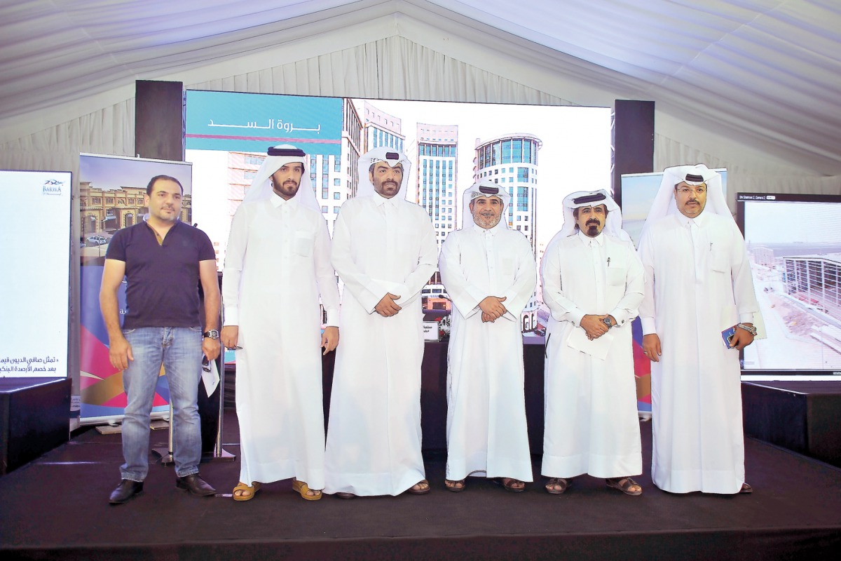 Salman bin Mohammed Al Muhannadi (third right), Barwa Group CEO, with other officials pose for a group photo after the press conference held at Madinat Al Mawater project yesterday. (Pic: Baher Amin/ The Peninsula)