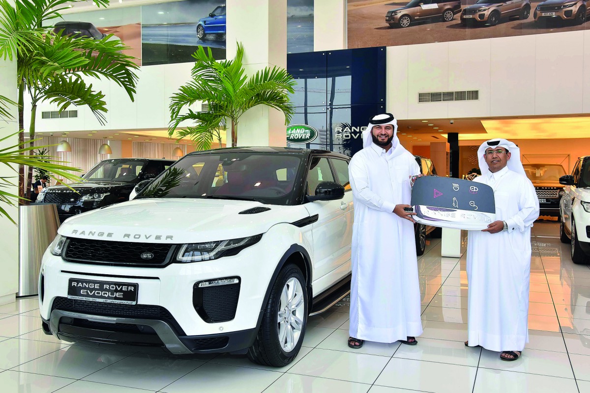A QNB official handing the keys of Range Rover Evoque  to the winner. 