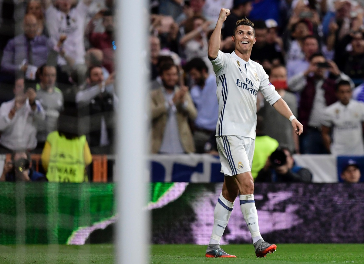 Real Madrid's Portuguese forward Cristiano Ronaldo celebrates his third goal during the UEFA Champions League semifinal first leg football match Real Madrid CF vs Club Atletico de Madrid at the Santiago Bernabeu stadium in Madrid, on May 2, 2017. (AFP / J