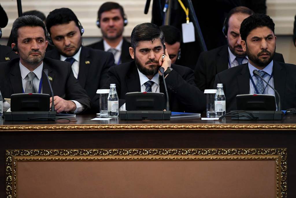 (FILES) This file photo taken on January 23, 2017 shows chief opposition negotiator Mohammad Alloush (C) of the Jaish al-Islam (Army of Islam) rebel group attending the first session of Syria peace talks at Astana's Rixos President Hotel.  AFP / Kirill KU