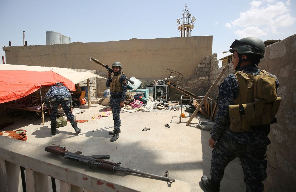 Members of the Iraqi security forces hold a position inside a building on the front line in Mosul's Old City on May 3, 2017, during an offensive to retake the city from Islamic State (IS) group fighters. / AFP / AHMAD AL-RUBAYE