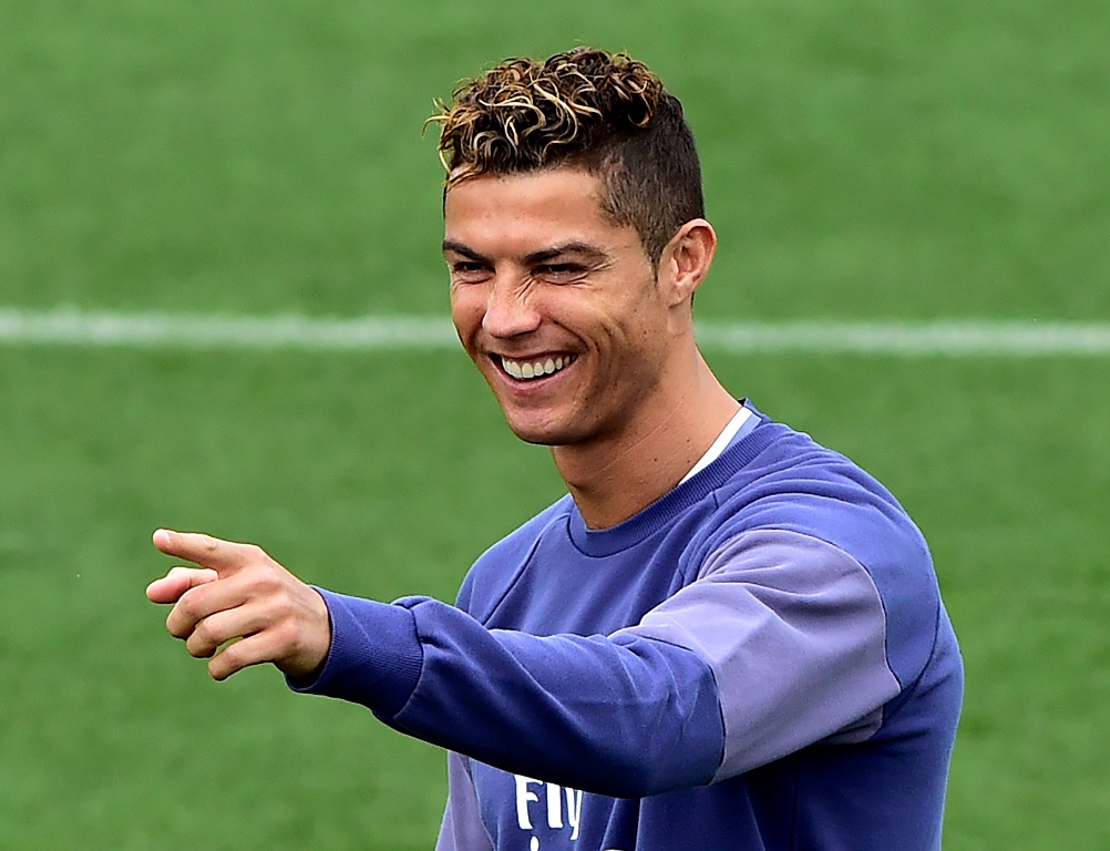 Real Madrid's Portuguese forward Cristiano Ronaldo smiles as he gestures during a training session at Valdebebas training ground in Madrid on May 5, 2017, on the eve of the Spanish League match football match Granada CF vs Real Madrid CF. / AFP / GERARD J
