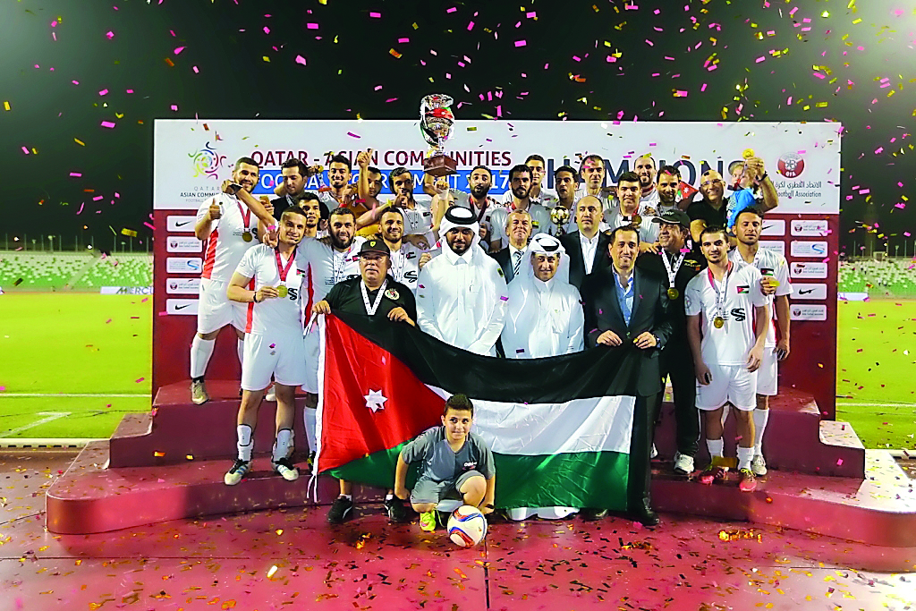 The players and officials of Jordan team celebrate on the podium during the medals ceremony of the fifth Asian Communities Football Tournament in Doha on Friday.