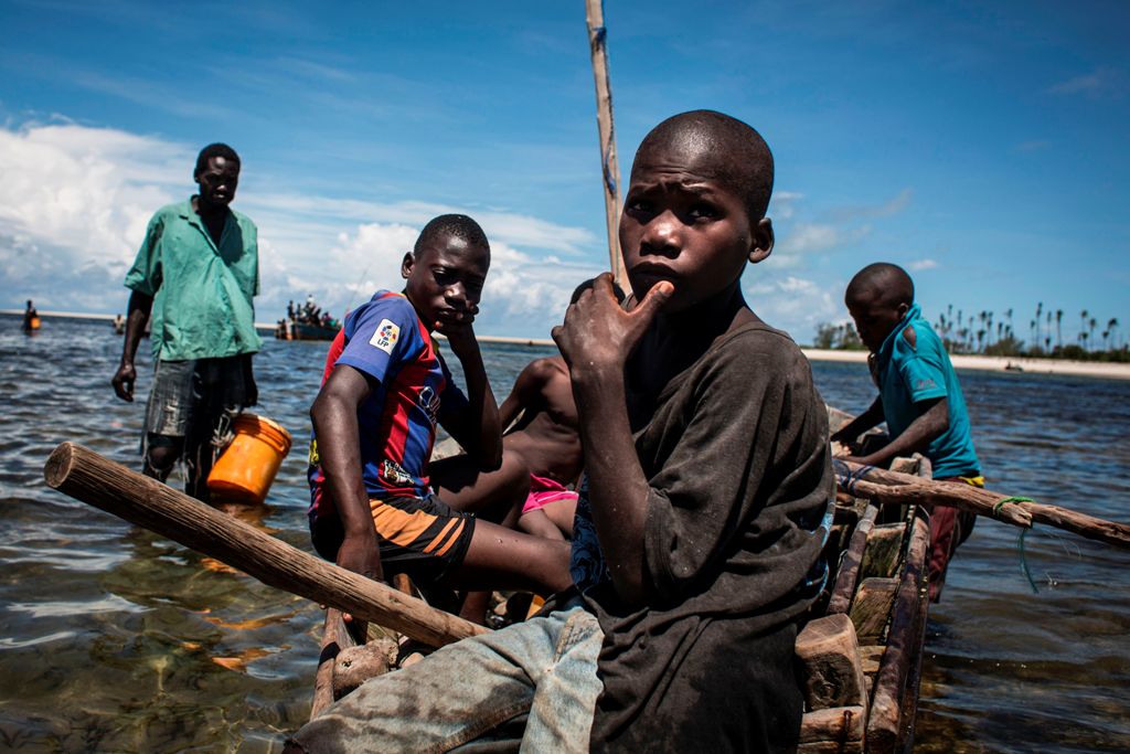 (FILES) This file photo taken on February 16, 2017 shows young Mozambican fishermen returning to the shore after several days of fishing in Palma, where large deposits of natural gas where found offshore. AFP / JOHN WESSELS