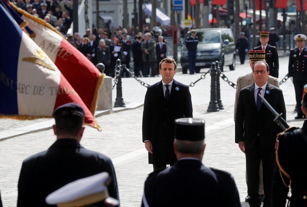 Outgoing French President Francois Hollande (R) and President-elect Emmanuel Macron attend a ceremony to mark the end of World War II at the Tomb of the Unknown Soldier at the Arc de Triomphe in Paris, France, May 8, 2017. REUTERS/Philippe Wojazer.