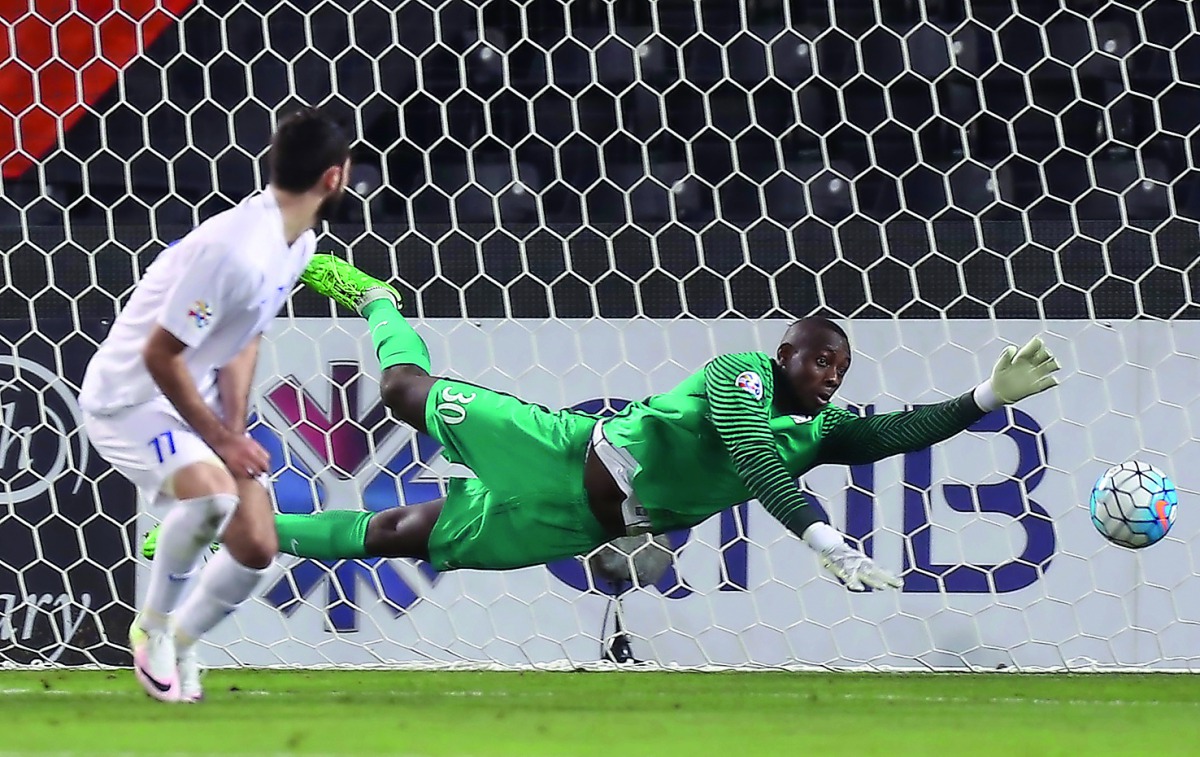Al Rayyan goalkeeper Oumar Barry tries to stop the ball from entering the net during their AFC Champions League match against Saudi Arabia's Al Hilal at the Jassim Bin Hamad Stadium in Doha .