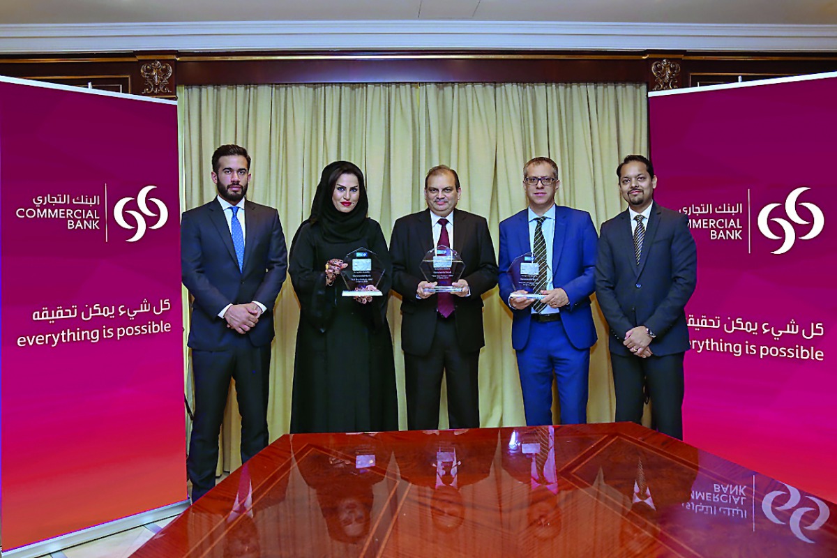 Commercial Bank officials pose for a group photo with the awards at the bank's headquarters in Doha.