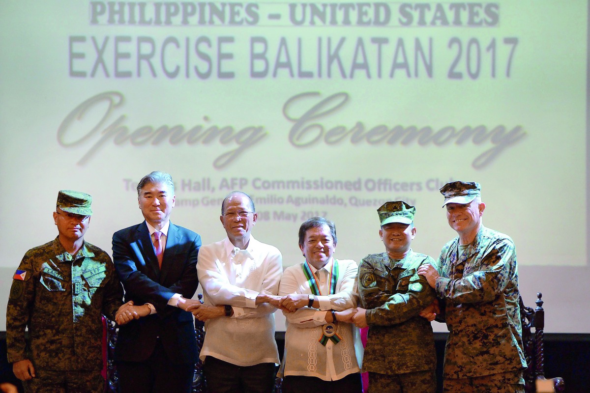 Officials link arms during the opening of the annual Philippine-US military exercises at Camp Aguinaldo, Quezon City, Manila, yesterday. 