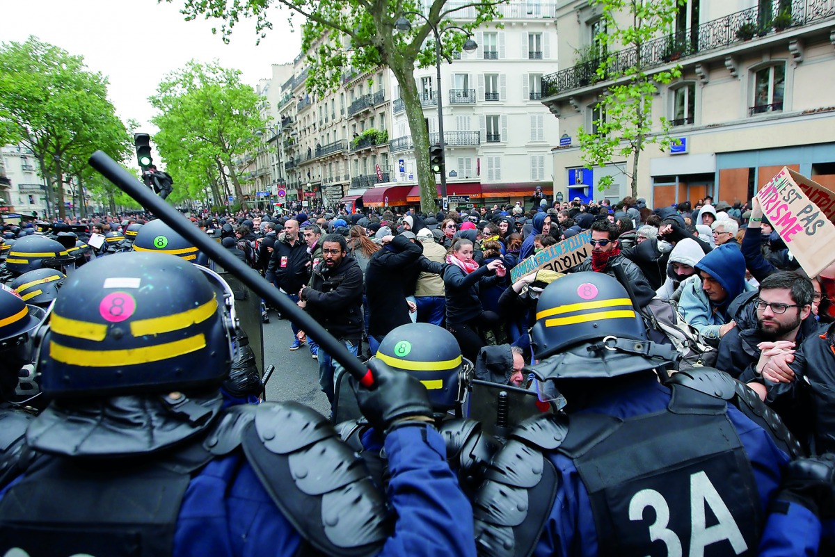 French riot police face off with demonstrators the day after the country went to the polls, in Paris, yesterday. Police arrested 141 people in eastern Paris in clashes with masked protesters after the election of pro-business independent Emmanuel Macron a