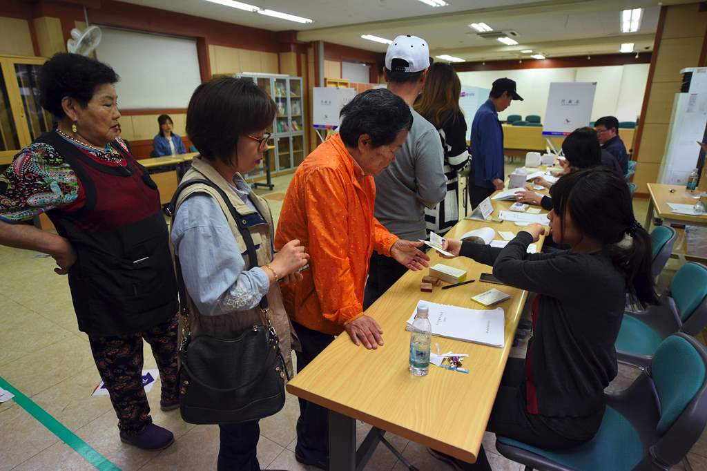 South Korean residents wait in a line to cast their votes in the presidential election at a polling station in Seoul on May 9, 2017. AFP / JUNG Yeon-Je
