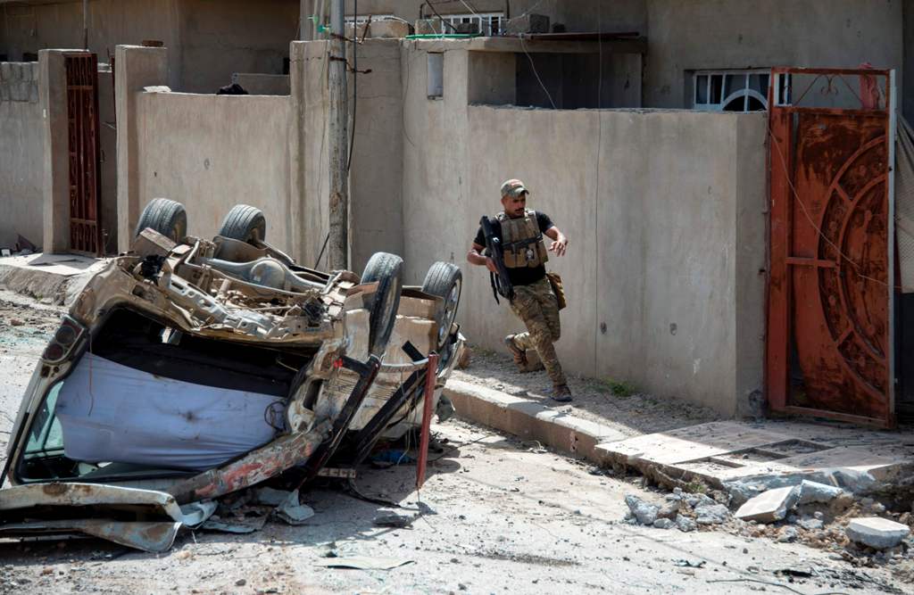 A member of the Iraqi forces runs to take a position in the northwestern al-Haramat neighbourhood of Mosul on May 9, 2017, during the ongoing offensive to retake the area from Islamic State (IS) group fighters.  AFP / FADEL SENNA
