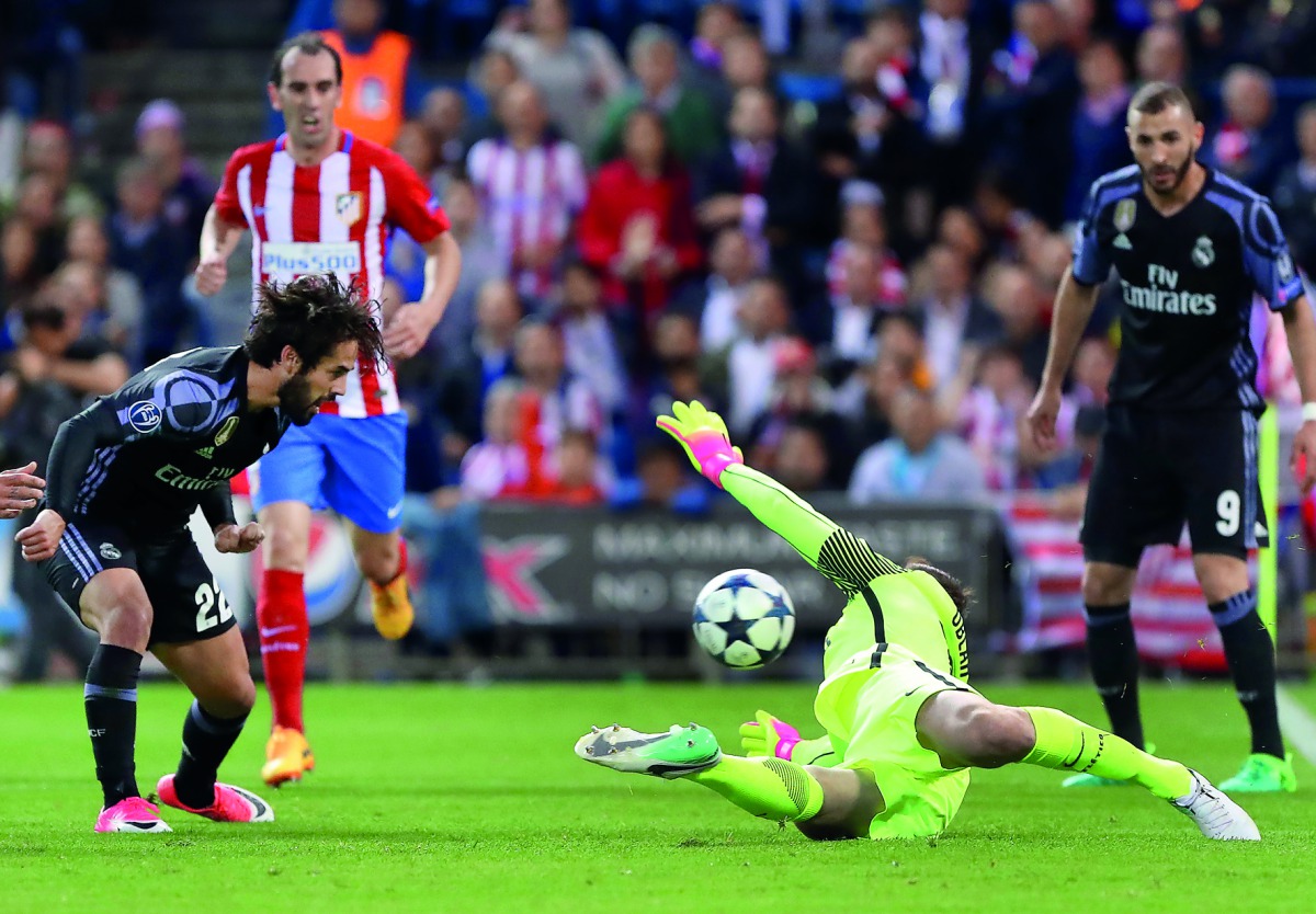 Real Madrid's midfielder Isco (left) scores a goal during the UEFA Champions League semifinal second leg football match against Club Atletico de Madrid at the Vicente Calderon Stadium in Madrid yesterday. Real Madrid secured their place in the Champions L