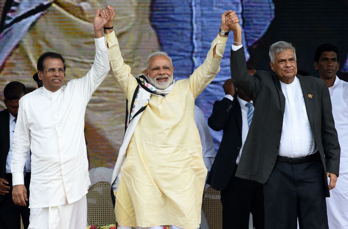 India's Prime Minister Narendra Modi (C) joins hands with Sri Lankan President Maithripala Sirisena (L) and Prime Minister Ranil Wickremesinghe (R) after addressing a public rally in the tea-growing town of Norwood, some 80kms east of Colombo on May 12, 2