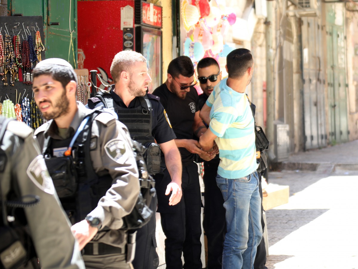 Israeli security forces take security take a man who entered into the crime scene as they inspect the crime scene after a Palestinian man was shot dead in an alleged stabbing attack in East Jerusalem, on May 13, 2017. (Mostafa Alkharouf / Anadolu Agency)