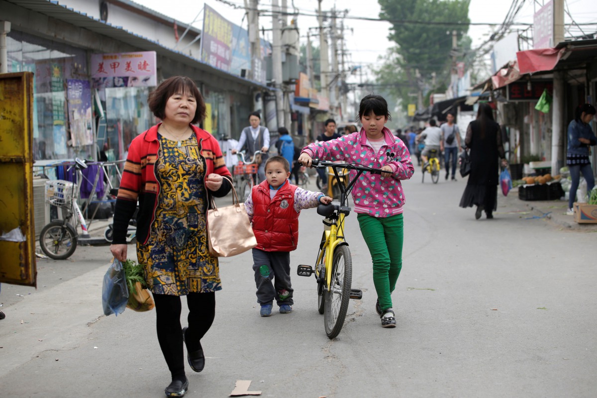 Children use an Ofo's shared bike at a residential area for migrant workers in a village on the outskirts of Beijing, China April 16, 2017. Picture taken April 16, 2017. REUTERS/Jason Lee