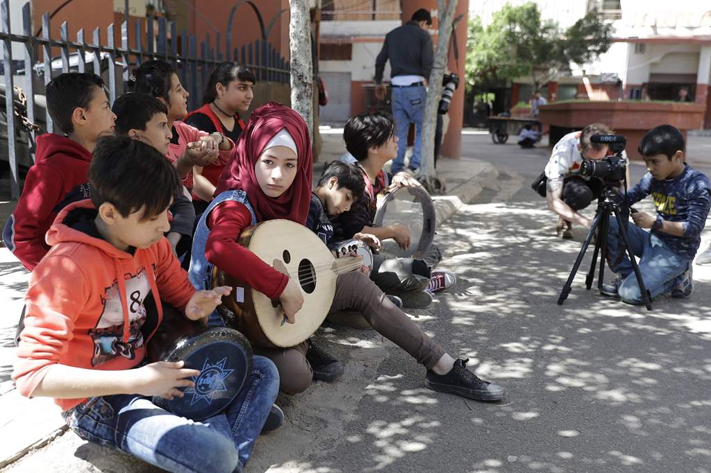 Syrian refugees from Minbej, nine-year-old Mostafa Abdallah (R) and thirteen year old Hanadi al-Hajj Abdallah (C) film a scene with their friends in Beirut's southern suburb of Shatila on April 5, 2017 as part of a refugee programme called the Refugee Fil