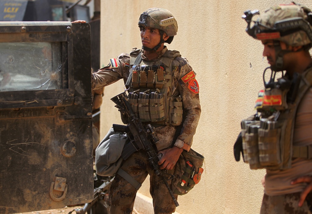 Members of the Iraqi Counter-Terrorism Service (CTS) take position as they advance towards Mosul's Al-Oraibi western district on May 14, 2017, during the ongoing offensive to retake the city from Islamic State (IS) group fighters. / AFP / AHMAD AL-RUBAYE