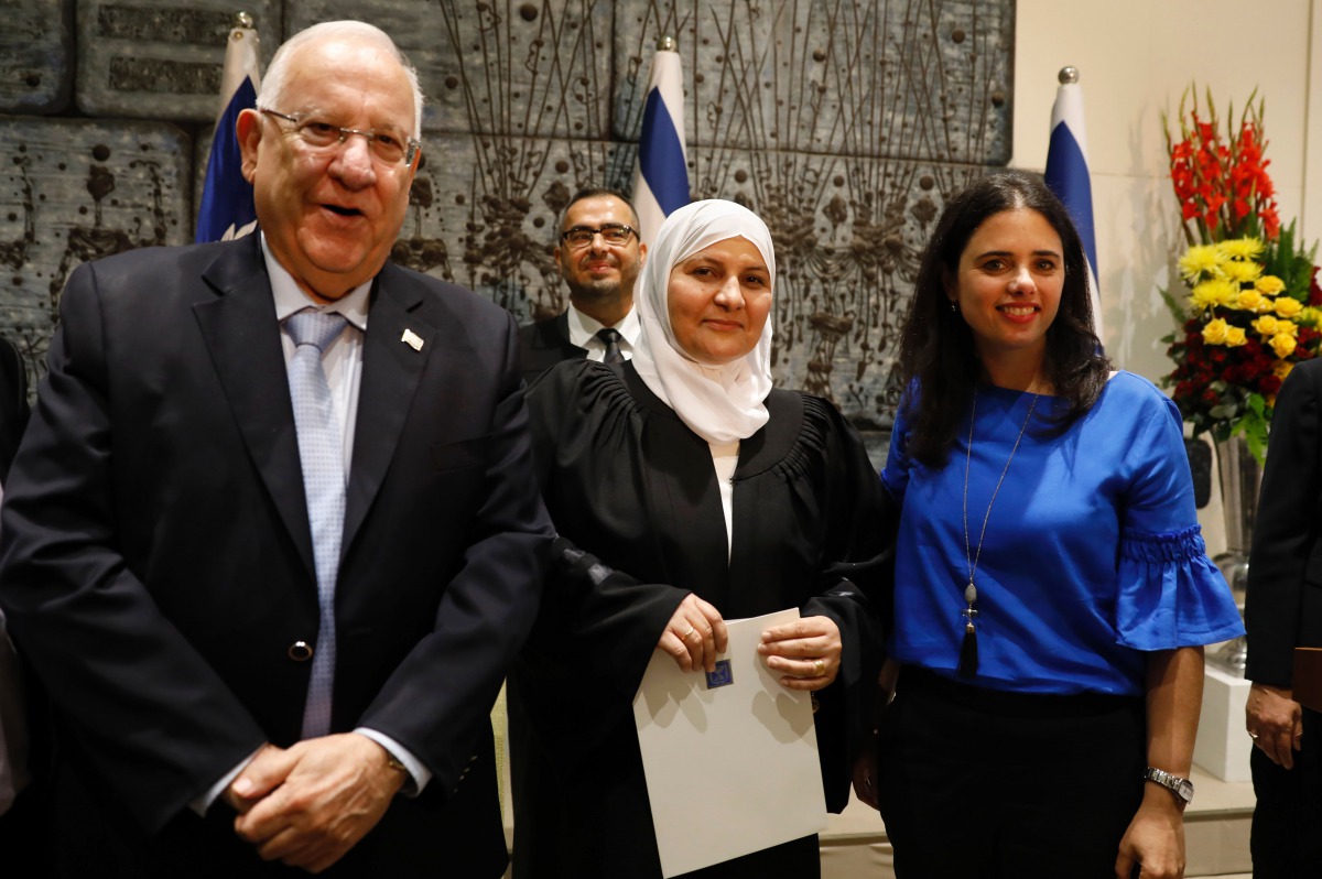 Israeli Justice Minister Ayelet Shaked (R) and Israeli President Reuven Rivlin (L) pose for a photo with Israeli Muslim Hana Khatib, the first woman in Israel to be appointed by an Israeli justice committee to become a religious judge, or qadi, in the cou