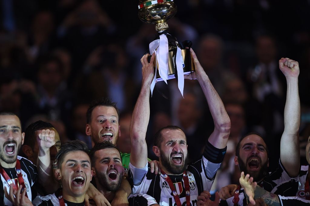 TOPSHOT - Juventus' defender from Italy Giorgio Chiellini holds the trophy with teammates Juventus' defender from Italy Leonardo Bonucci (L), Juventus' forward from Argentina Paulo Dybala (2ndL), Juventus midfielder Miralem Pjanic and Juventus' forward fr