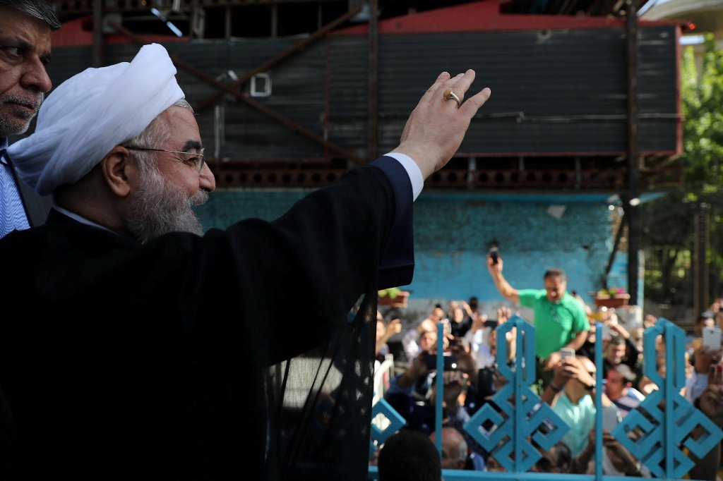 Iran's President Hassan Rouhani waves to supporters at a polling station during the presidential election in Tehran, Iran, May 19, 2017. President.ir