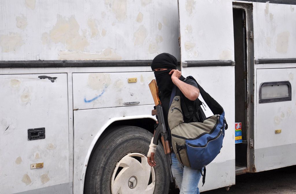 A Syrian opposition fighter arrives at a checkpoint manned by regime forces ahead of their evacuation from Waer neighbourhood, the last opposition-held district in the central city of Homs, on May 20, 2017. AFP / STRINGER
