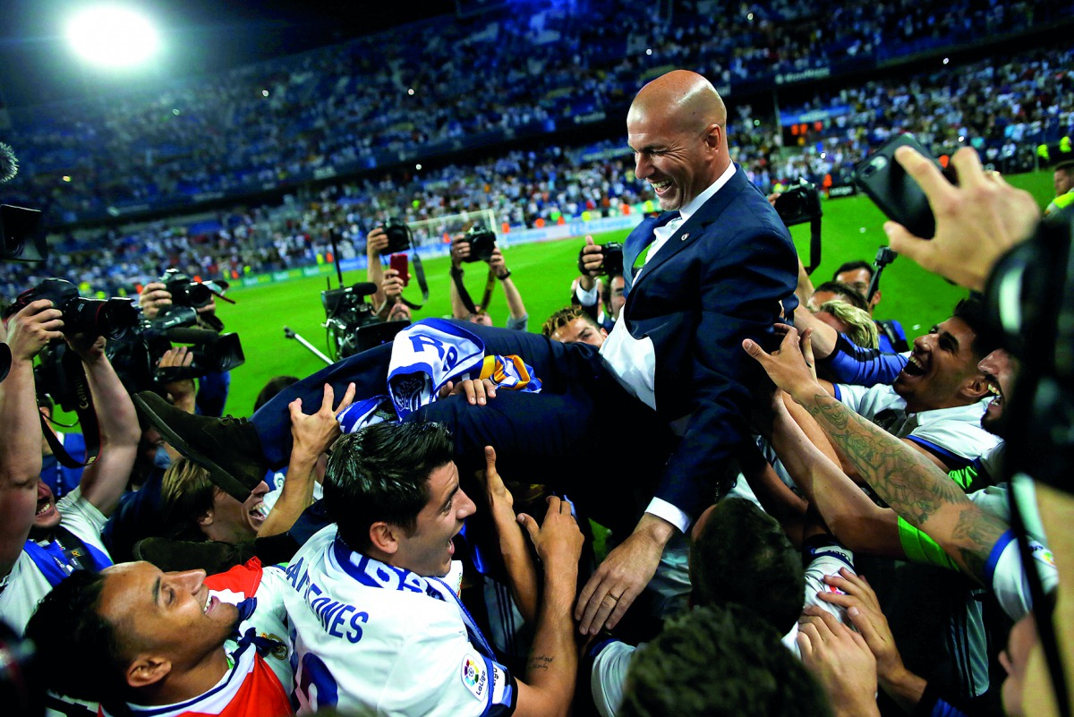 Real Madrid coach Zinedine Zidane is carried by his players as they celebrate after winning La Liga title on Sunday.   