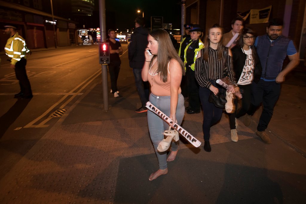 Concert goers react after fleeing the Manchester Arena in northern England where U.S. singer Ariana Grande had been performing in Manchester, Britain, May 22, 2017. REUTERS/Jon Super