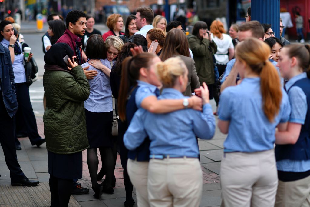 Retail staff hug each other after being evacuated from the Arndale Centre shopping mall in Manchester, northwest England on May 23, 2017 following a security alert the day after a deadly terror attack at the Manchester Arena. AFP / Ben STANSALL
