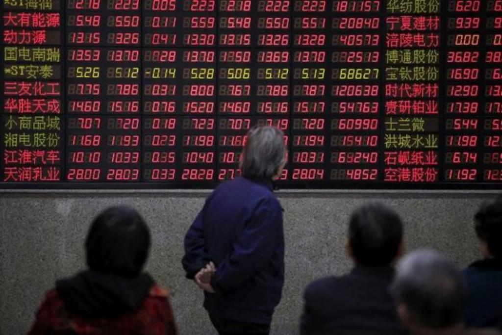  Investors look at an electronic board showing stock information at a brokerage house in Shanghai, China
