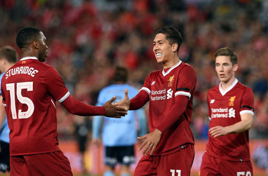 Liverpool's Daniel Sturridge (L) congratulates teammate Roberto Firmino (C) after his goal against Sydney FC during their end-of-season friendly football match at the Olympic Stadium in Sydney on May 24, 2017. AFP / SAEED KHAN