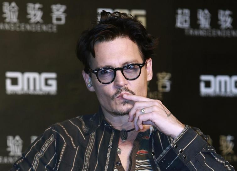 Actor Johnny Depp gestures during a promotional event of his new movie ''Transcendence'', on his first visit to China in Beijing, March 31, 2014. REUTERS