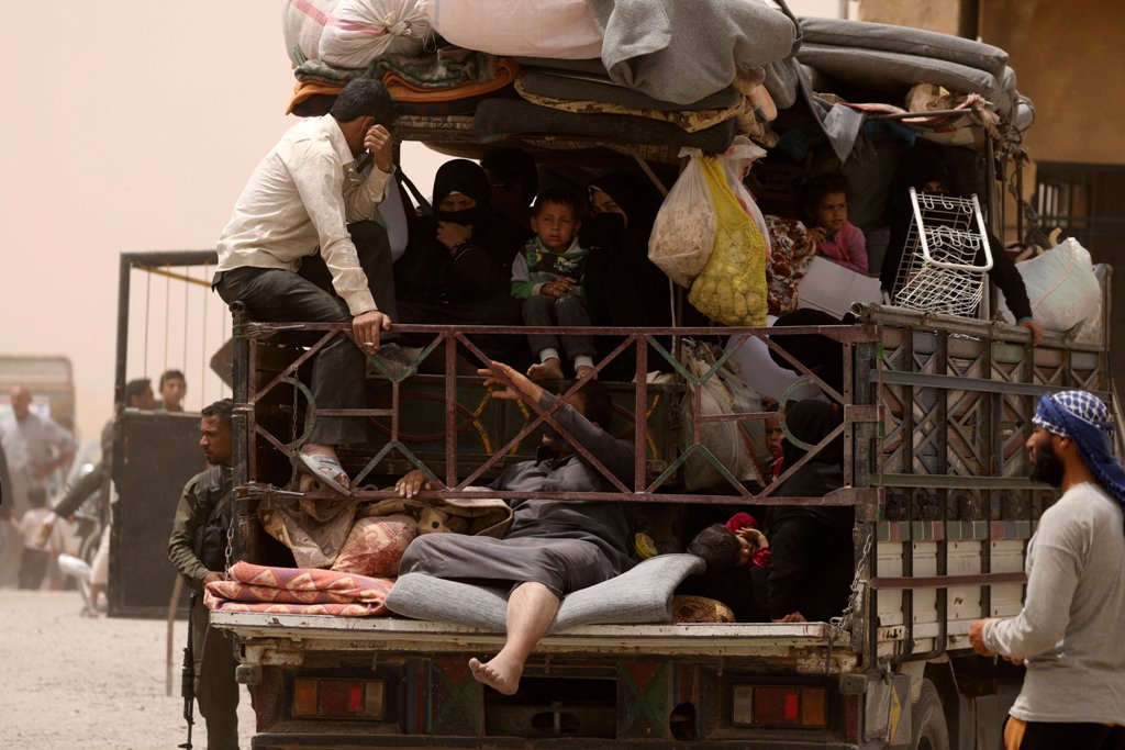 FILE PHOTO: Internally displaced people who fled Raqqa city ride a vehicle with their belongings in a camp near Ain Issa, Raqqa Governorate, Syria May 19, 2017. REUTERS/Rodi Said/File Photo