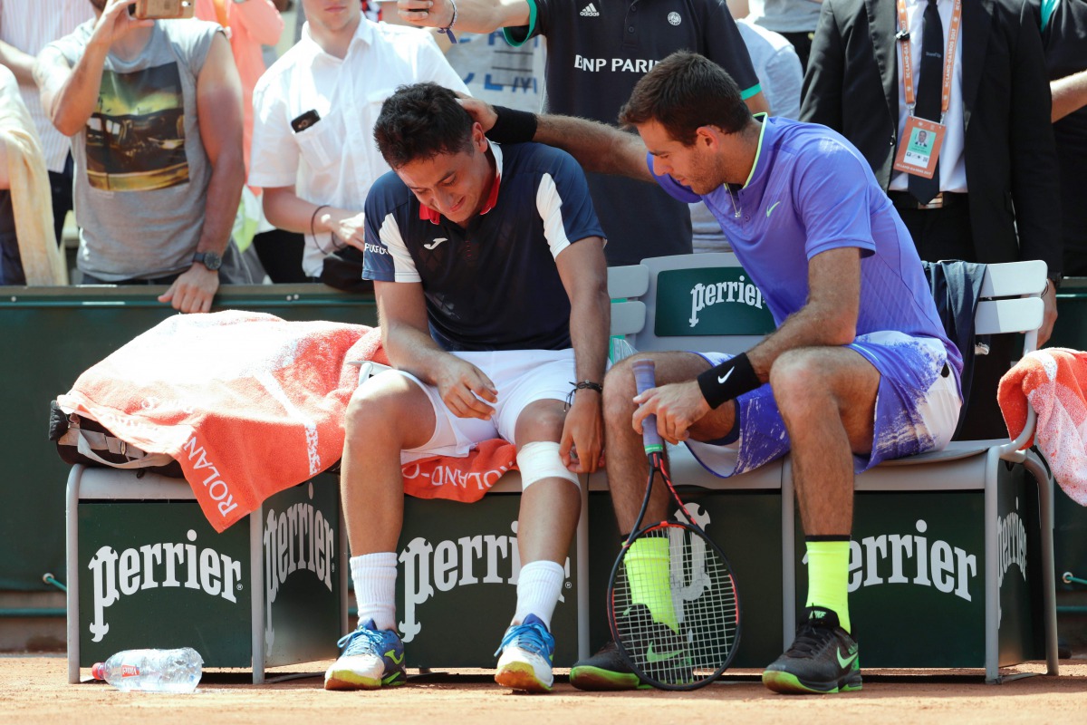 Spain's Nicolas Almagro (L) is comforted by Argentina's Juan Martin Del Potro as he has to give up due to an injury during their tennis match at the Roland Garros 2017 French Open on June 1, 2017 in Paris. (AFP / Thomas SAMSON)