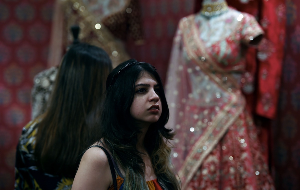 An Indian woman looks at different designer dresses at a stall during the Vogue Wedding Show 2016 in New Delhi on August 5, 2016 (AFP) 