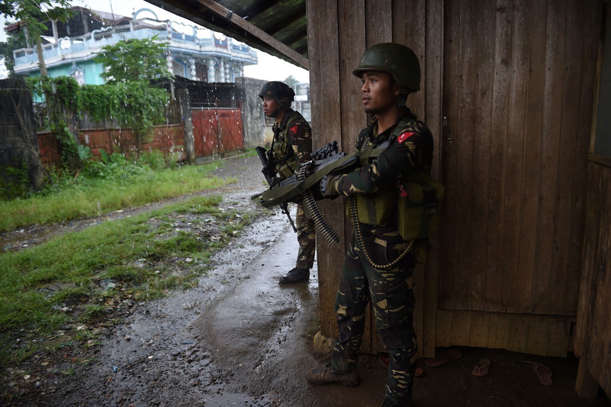 Government troops take position against enemy snipers as they escort rescued workers and trapped residents near the town center where heavy fighting between troops and Muslim militants have been raging in Marawi, in southern island of Mindanao on June 1, 