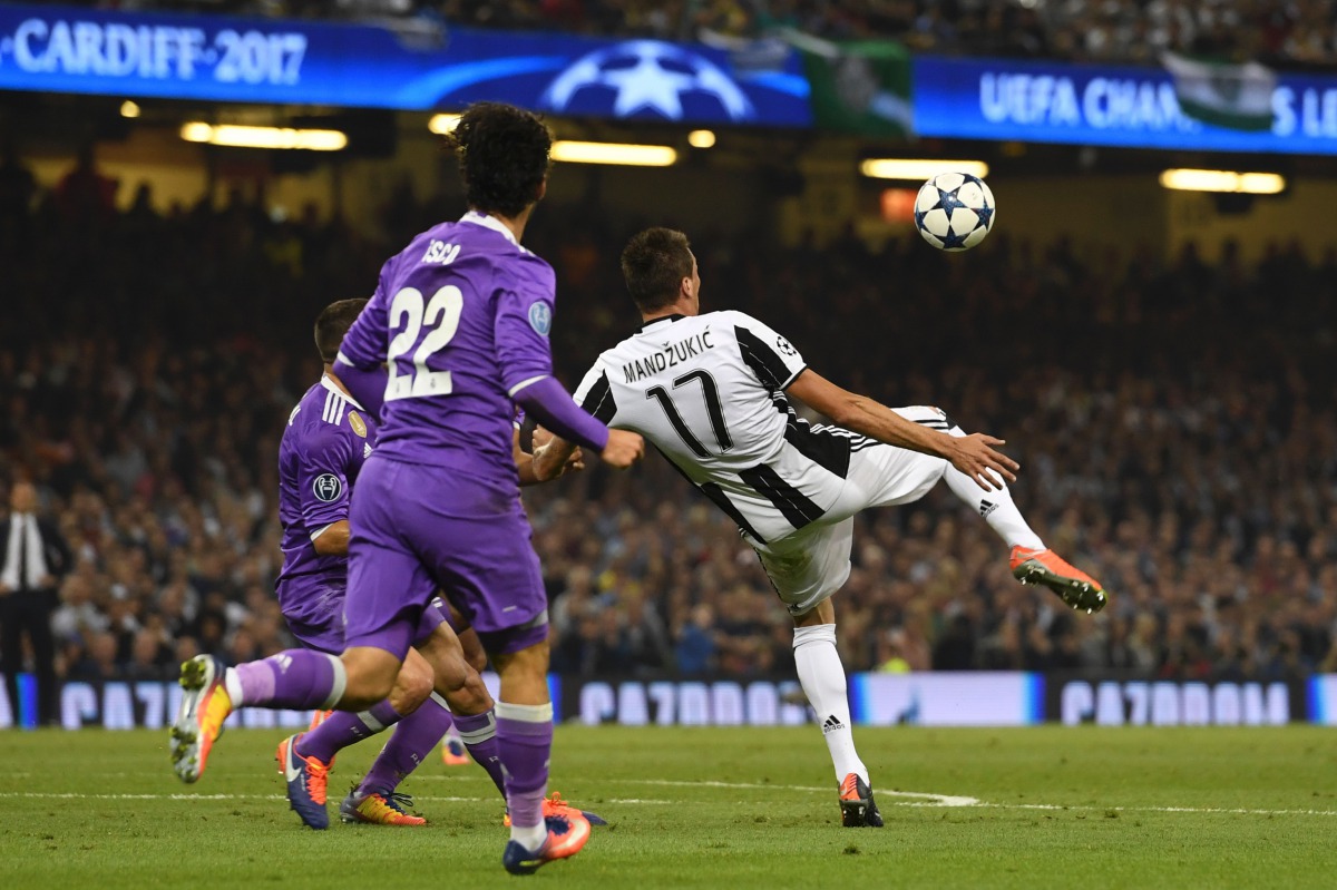 Juventus' Croatian striker Mario Mandzukic shoots to score their first goal during the UEFA Champions League final football match between Juventus and Real Madrid at The Principality Stadium in Cardiff, south Wales, on June 3, 2017. (AFP / Glyn KIRK)