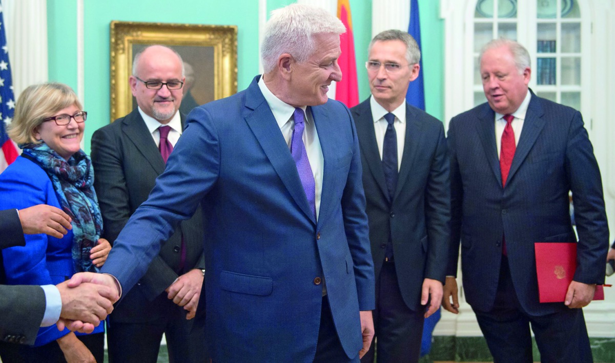 Montenegro Prime Minister Dusko Markovic (centre) shakes hands and is welcomed to Nato during the Deposit of Montenegro's Instrument of Accession to Nato (under Shannon's arm), formally triggering Montenegro's membership in the Nato Alliance, yesterday.
