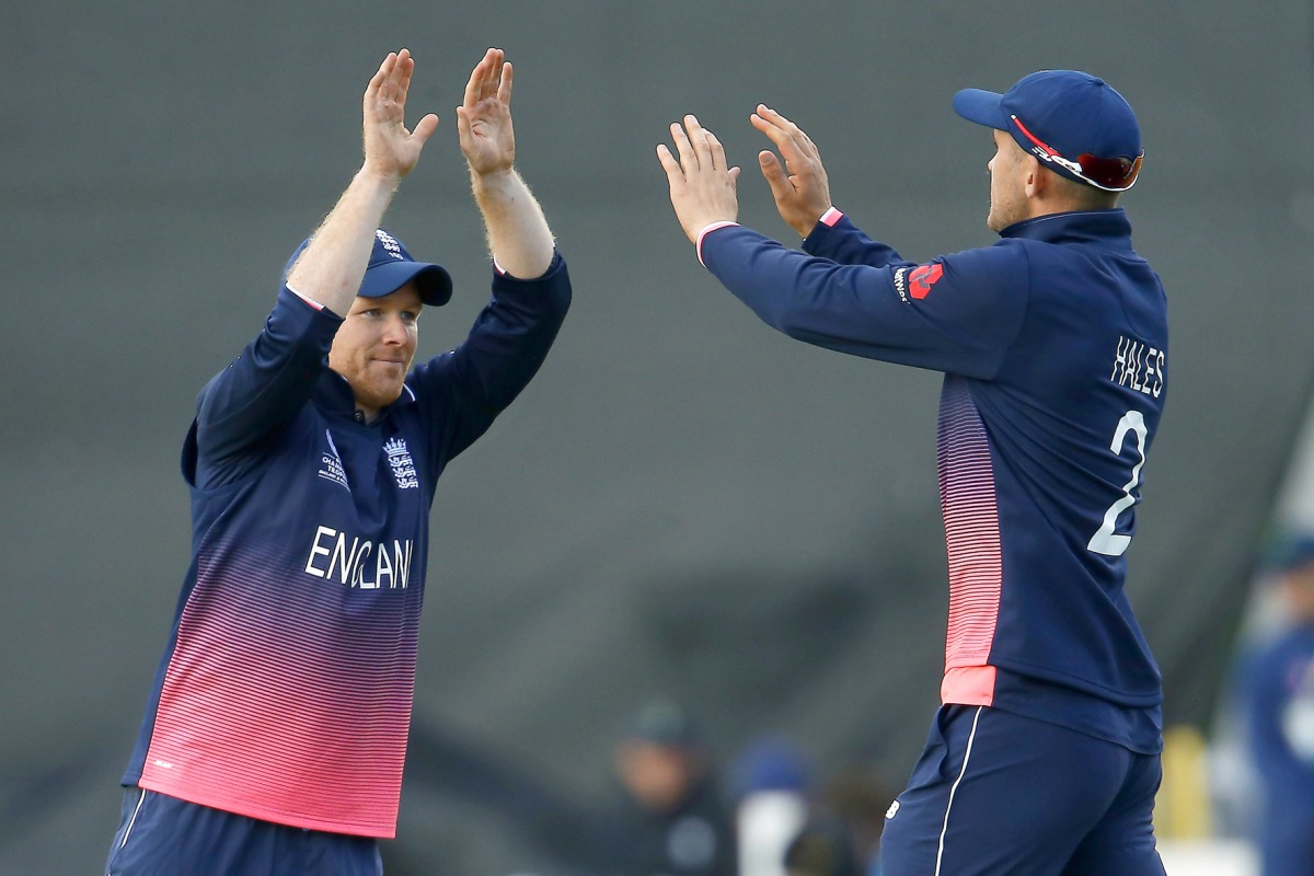 England's Alex Hales and Eoin Morgan (left) celebrate the wicket of New Zealand's James Neesham during their Champions Trophy match at Sophia Gardens on Tuesday.