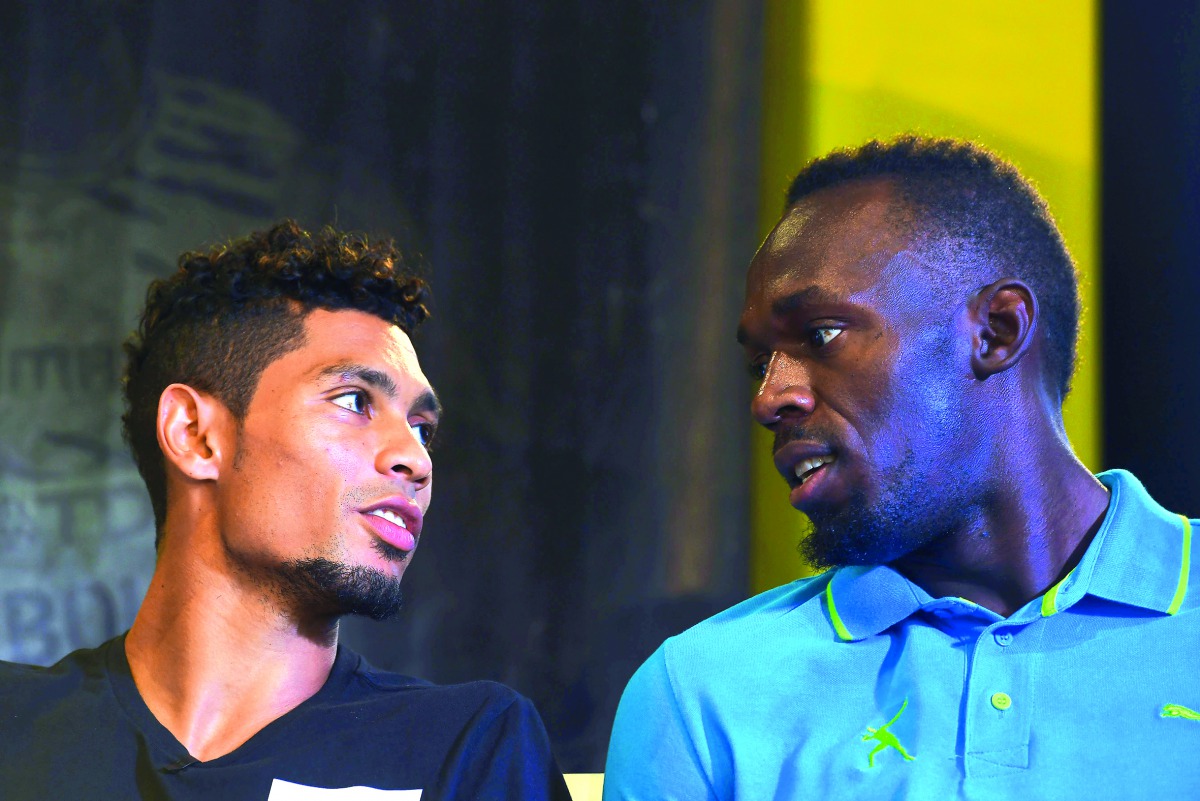 Usain Bolt of Jamaica (right) chats with Wayde Van Niekerk of South Africa during a press conference in Kingston, on Thursday.