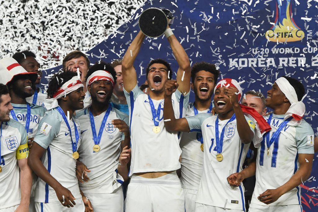 England's players celebrate with the trophy during the awards ceremony after winning the U-20 World Cup final football match between England and Venezuela in Suwon on June 11, 2017. / AFP / JUNG Yeon-Je