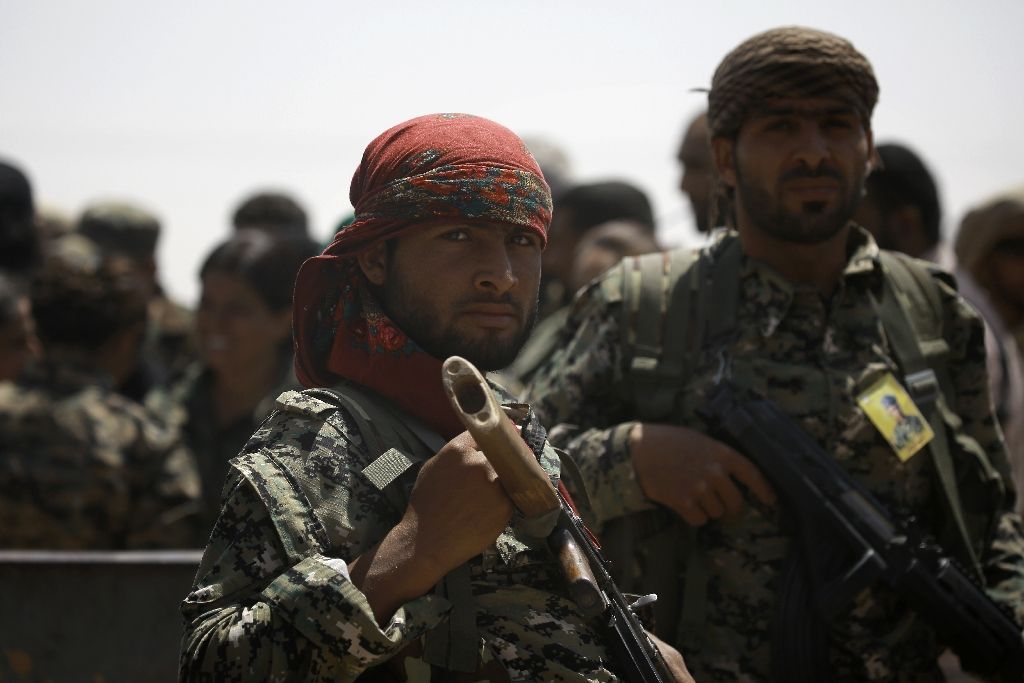 Members of the US-backed Syrian Democratic Forces (SDF) stand in the village of Hazima on the northern outskirts of the Islamic State (IS) group's Syrian bastion of Raqa on June 6, 2017 (AFP Photo/DELIL SOULEIMAN).