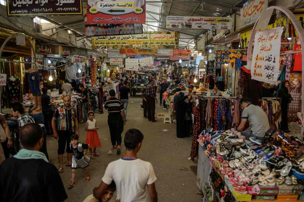 Iraqis shop at the market of Prophet Younis in eastern Mosul on June 13, 2017. / AFP / MOHAMED EL-SHAHED