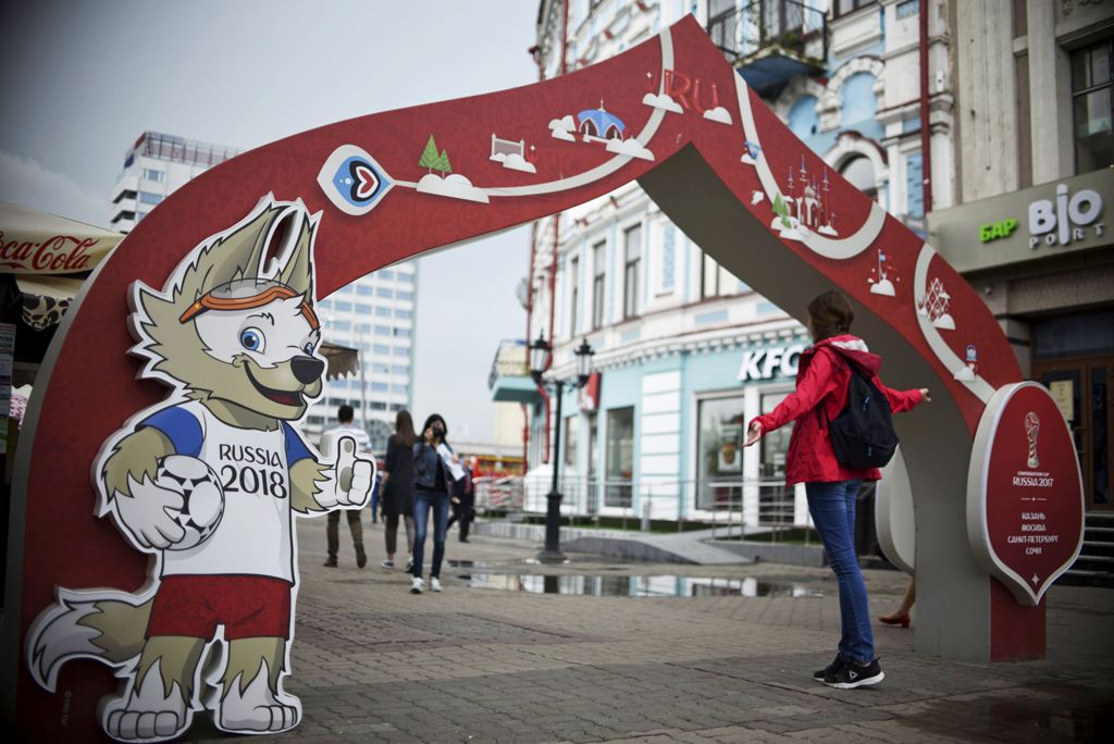 A girl poses for a picture in front of a banner promoting the 2017 Russia Confederations Cup football tournament in Kazan, Russia on June 16, 2017. / AFP / YURI CORTEZ
