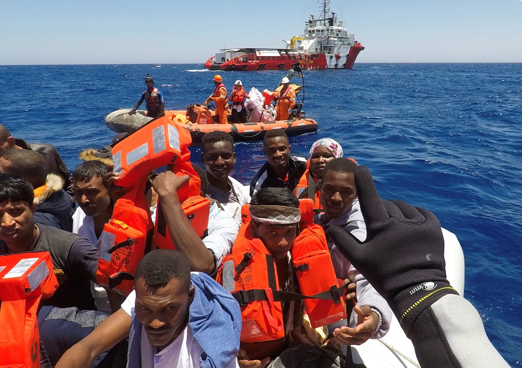 Migrants on a dinghy are rescued by 