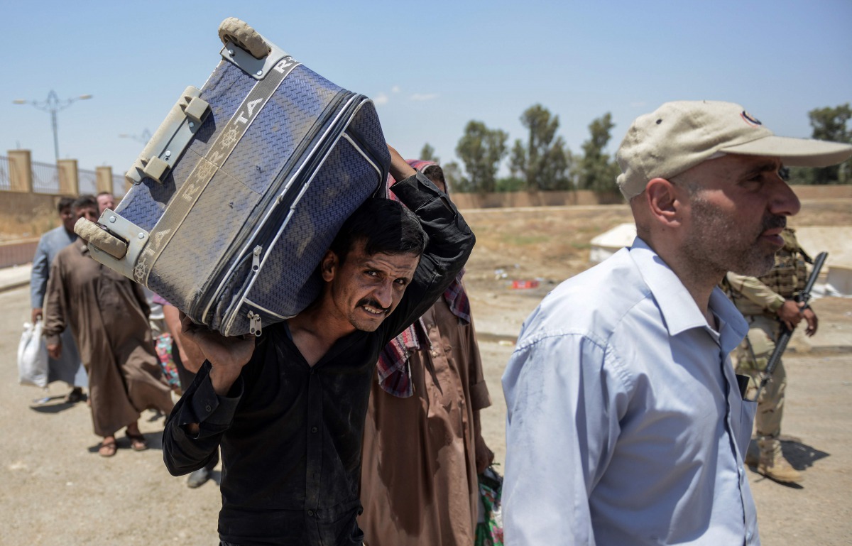 Displaced Iraqis arrive at a temporary camp in the compound of the closed Nineveh International Hotel in Mosul on June 16, 2017 which was recovered by Iraqi troops from Islamic State group fighters earlier in the year. (AFP / MOHAMED EL-SHAHED)