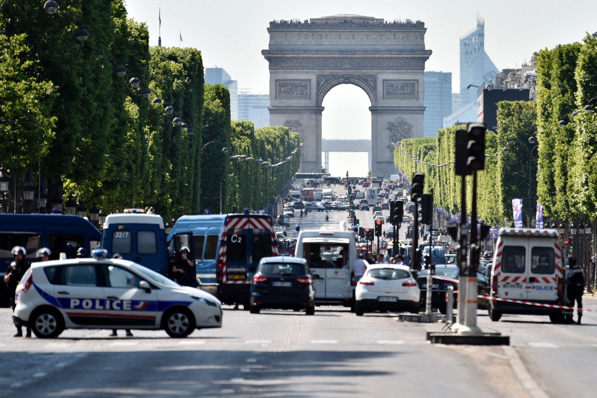 Police seal off the Champs-Elysees avenue on June 19, 2017 in Paris after a car crashed into a police van before bursting into flames, with the driver being armed, probe sources said. (AFP / ALAIN JOCARD)
